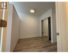 A room with a wooden floor and white walls, with a door on the right side.