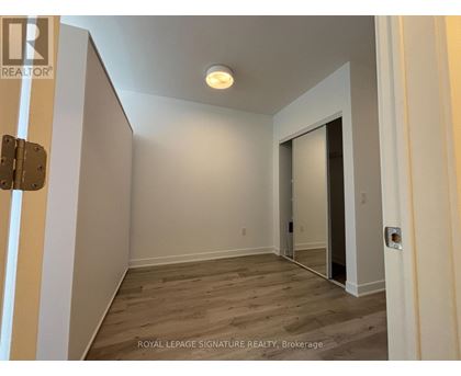 A room with a wooden floor and white walls, with a door on the right side.