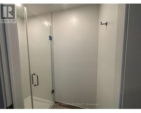 A white bathroom with a glass door and a handle on the door.