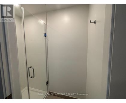 A white bathroom with a glass door and a handle on the door.