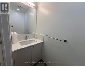 A white bathroom with a sink and a mirror.