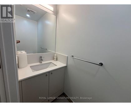 A white bathroom with a sink and a mirror.