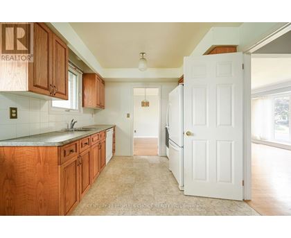 A kitchen with wooden cabinets and a white door.