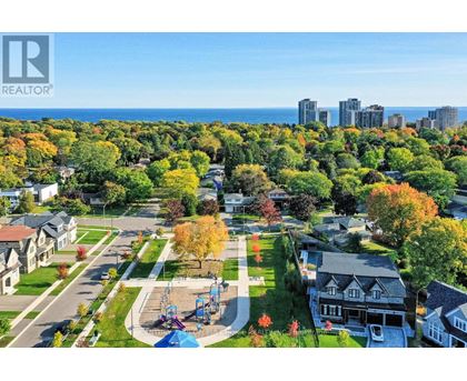 A park with a playground and a slide is surrounded by houses.