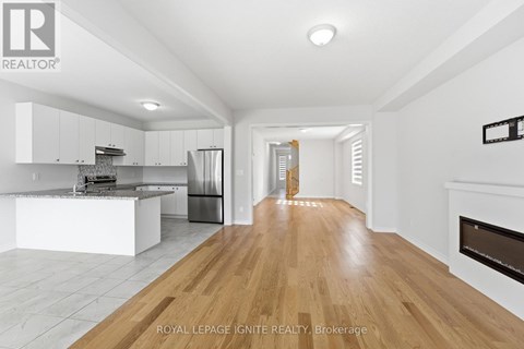 A spacious kitchen with white cabinets and a wooden floor.