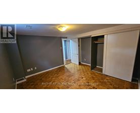 A room with a wooden floor and a wall with a window.