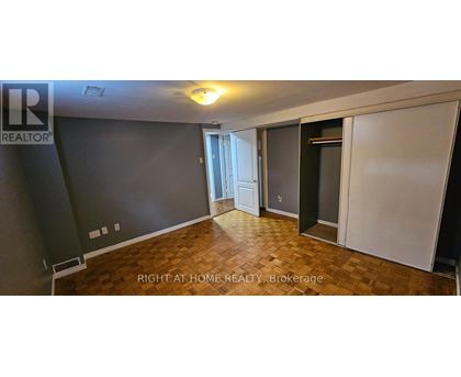 A room with a wooden floor and a wall with a window.