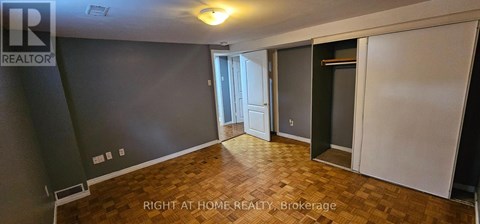 A room with a wooden floor and a wall with a window.