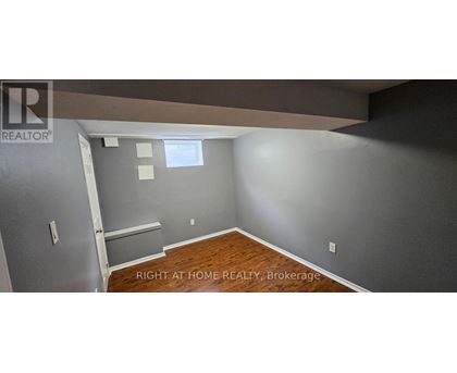 A room with a wooden floor and a wall with a window.