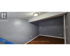 A room with a brokerage sign on the wall.