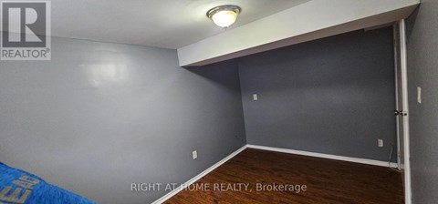 A room with a brokerage sign on the wall.