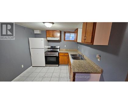 A kitchen with a white refrigerator, brown cabinets, and a granite countertop.