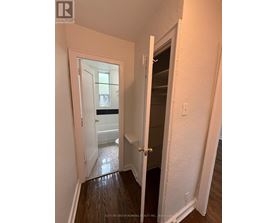 A hallway with a doorway leading to a bathroom.