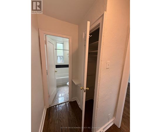 A hallway with a doorway leading to a bathroom.