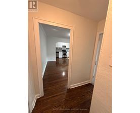 A hallway with a white door and a white wall.