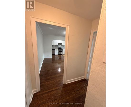 A hallway with a white door and a white wall.