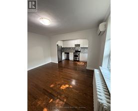 A room with wooden floors and a white radiator on the wall.