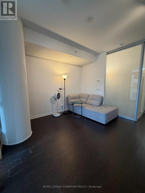 A living room with a white sofa and a floor lamp.