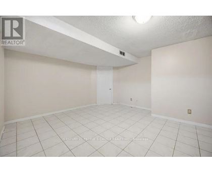 A spacious room with a door and a light on the ceiling.