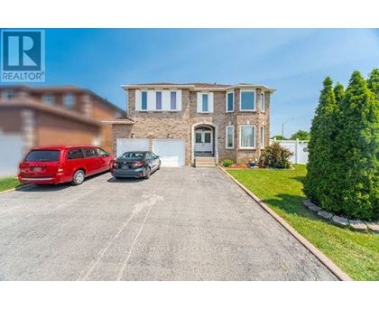 A large house with a driveway and two cars parked in front.