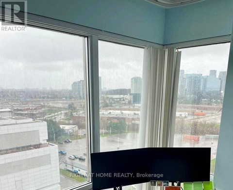 A window with a view of a cityscape and a sign that says "RICHAT HOME REALTY, Brokerage".