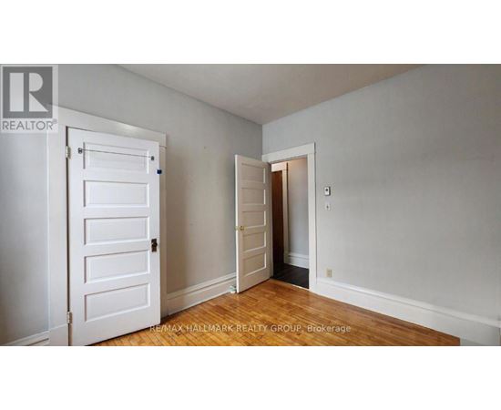 A room with a white door and a wooden floor.