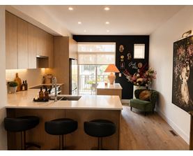 A kitchen with a bar area and a green chair.