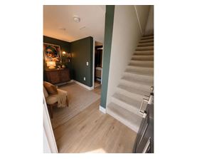 A staircase with a beige carpeted runner leads up to a second floor.