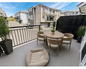 A patio with a table and chairs overlooking a street.
