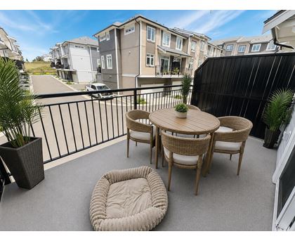 A patio with a table and chairs overlooking a street.