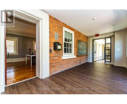 A room with a brick wall and wooden floors.