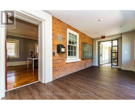 A room with a brick wall and wooden floors.