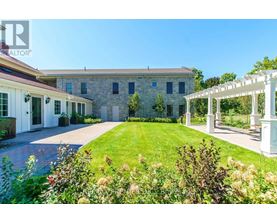 A house with a white pergola and a garden in front.