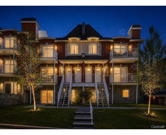 A large, well-lit, two-story house with a staircase leading to the second floor.