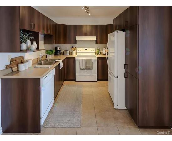 A kitchen with brown cabinets and white appliances.