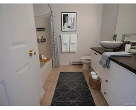 A bathroom with a toilet, sink, and a mirror.