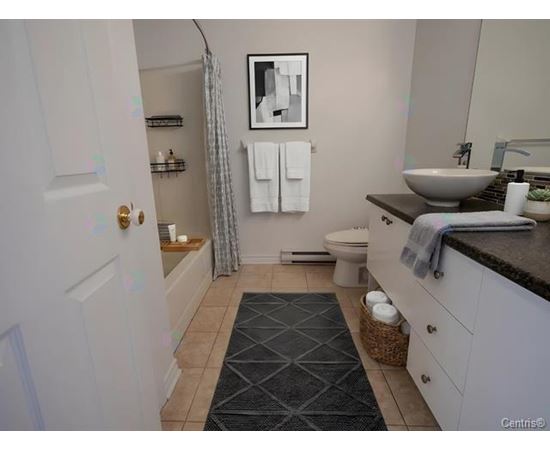 A bathroom with a toilet, sink, and a mirror.