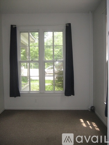 A room with a window and a carpet on the floor.