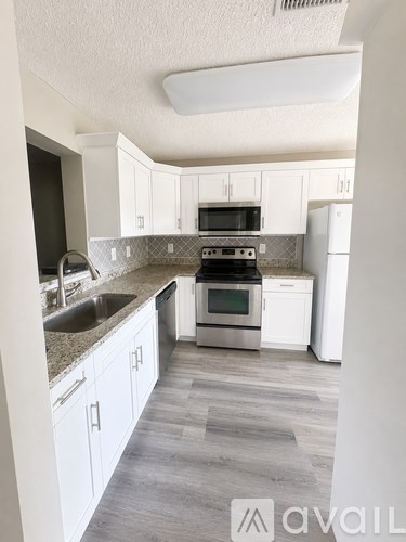 A kitchen with white cabinets and a stove top oven.