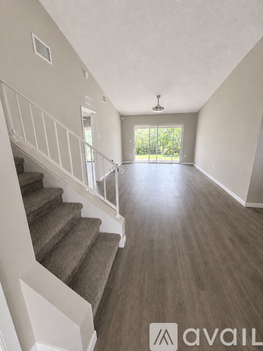 A spacious room with a staircase leading to a balcony.