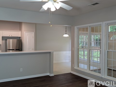 A kitchen with white cabinets and a ceiling fan.