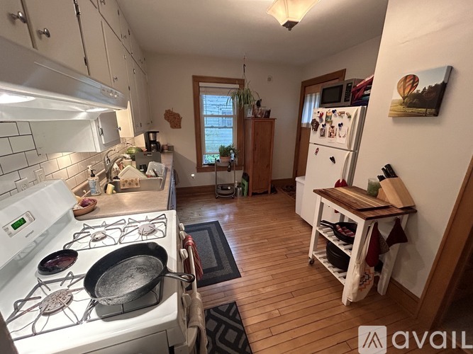 A kitchen with a white stove top and a white fridge.