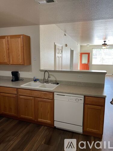 A kitchen with wooden cabinets and a white dishwasher.