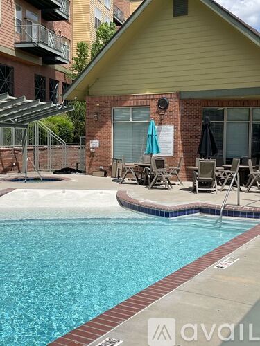 A pool with a red brick building behind it.