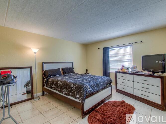 A bedroom with a bed, dresser, and mirror.