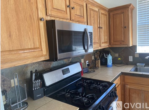 A kitchen with wooden cabinets and a black stove top.