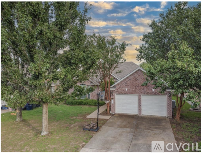 A house with a driveway and trees in front of it.