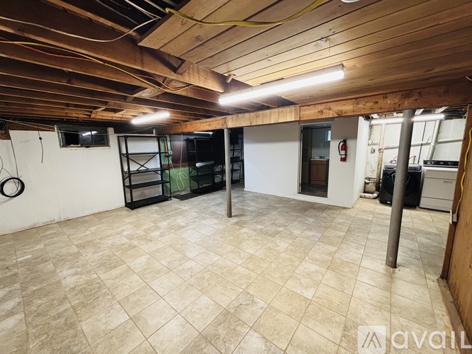 A spacious room with wooden ceiling and tiled floor.