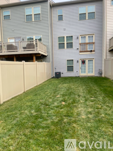 A grey apartment building with a green lawn in front.