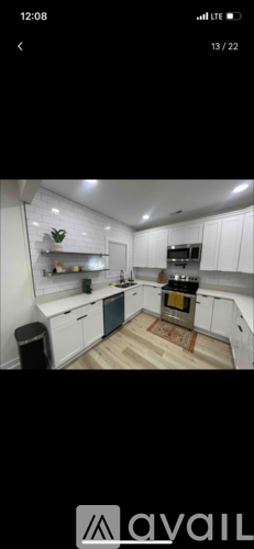 A kitchen with white cabinets and a wooden floor.